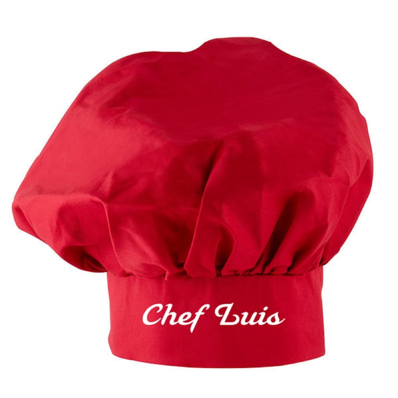 Puede incluir: Un gorro de chef rojo con el texto "Chef Luis" bordado en blanco en la banda.