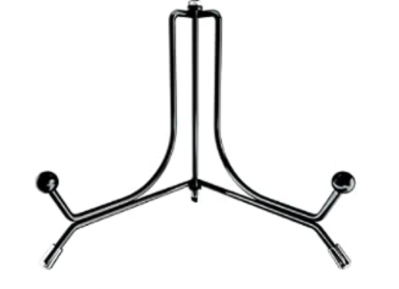 Puede incluir: Un soporte de exhibici&oacute;n de metal negro con una base de tres patas y un soporte vertical. El soporte tiene un dise&ntilde;o curvo y es adecuado para sostener platos u otros objetos decorativos. El soporte est&aacute; dise&ntilde;ado para sostener objetos en posici&oacute;n vertical.