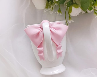 een mok met een roze strik. Glamoureuze meisjesbeker, cadeau vrijgezellenfeest, porseleinen mok, decor met strik, cadeau voor koffieliefhebber. schattige mok