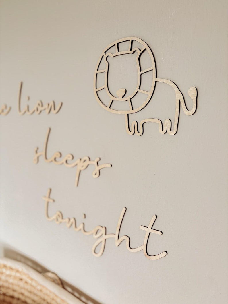 May include: Wooden wall decor with the text "The lion sleeps tonight" and a cutout of a lion with a mane.