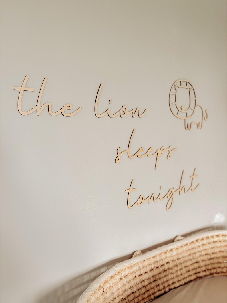 May include: Wooden wall decor with the words "the lion sleeps tonight" and a cutout of a lion's head.