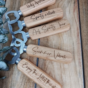 Könnte beinhalten: Satz von fünf Holz-Flaschenöffnern mit gravierten Sprüchen. Die Sprüche sind "Holy Aperol", "Spritz o'clock", "Auf Spritz Tour", "Summer Vibes" und "Enjoy the Little Things".