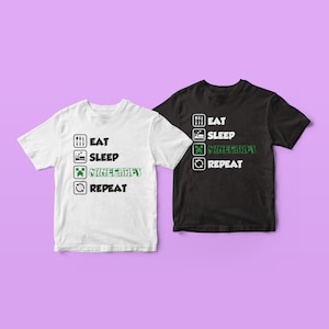 May include: Two t-shirts with a graphic design featuring a list of activities: eat, sleep, Minecraft, repeat. The t-shirts are white and black.