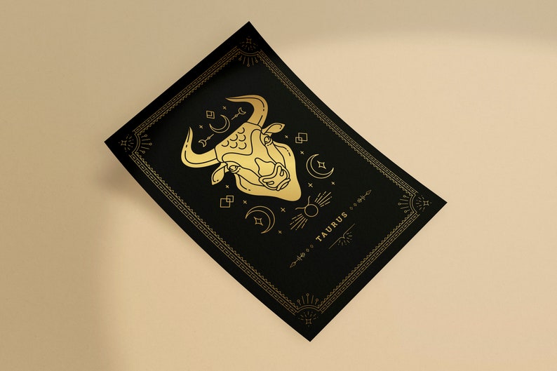 May include: A black and gold print with a stylized illustration of a bull's head and the word "TAURUS" in a decorative font.