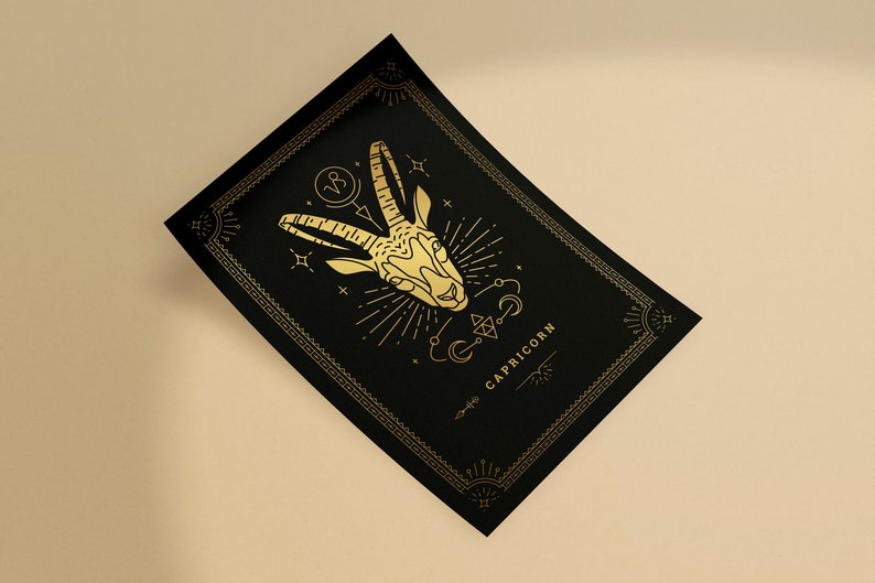 May include: Black rectangular card with a gold Capricorn zodiac illustration. The design features a goat head, celestial symbols, and the word "CAPRICORN" in gold. The card has a decorative border.