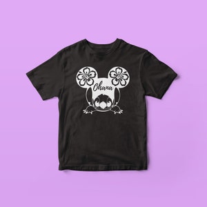 May include: Black t-shirt with a white graphic of a cartoon character with flower-shaped ears. The character's name "Ohana" is written on the shirt.