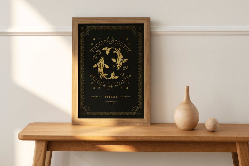 May include: A framed print with a black background and gold accents. The print features a stylized illustration of two fish, the astrological symbol for Pisces, and the word "Pisces".