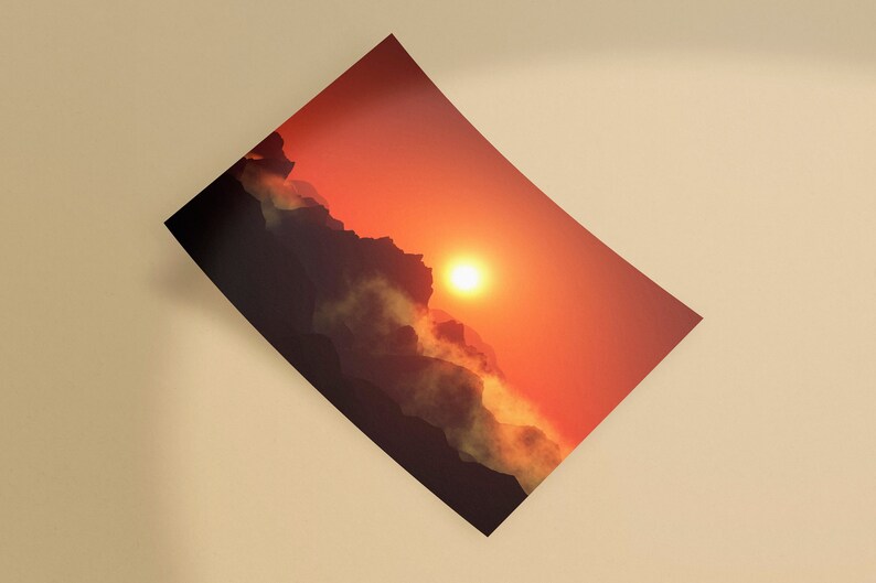 May include: A print depicting a sunset over a mountain range. The sky transitions from a bright orange near the sun to a darker red. The mountains are silhouetted, with clouds and mist adding depth to the scene.
