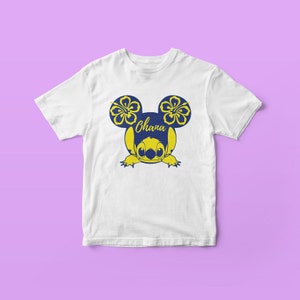 May include: White t-shirt with a blue Stitch character wearing yellow hibiscus flowers on its ears. The text "Ohana" is written on the character's head.
