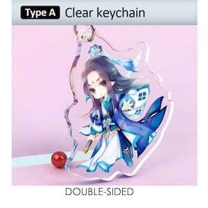May include: Clear double-sided keychain with a cartoon character in blue and white clothing. The keychain has a silver ring and the text "Clear keychain" is at the top. The words "Type A" are also visible. A red sphere is in the background.