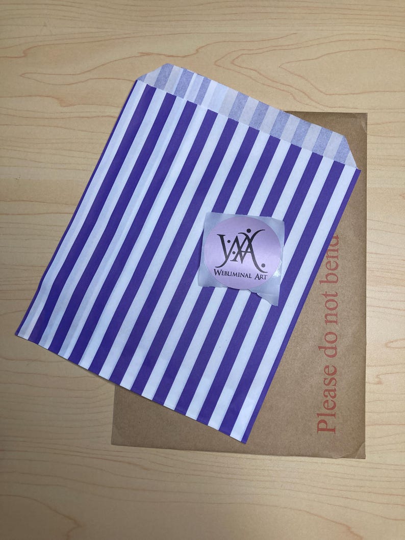 May include: A purple and white striped paper bag with a sticker that says "Webluminal Art" on a brown cardboard envelope. The envelope has the text "Please do not bend" printed on it.
