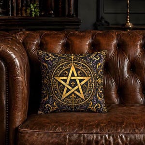 Może przedstawiać: Kwadratowa poduszka dekoracyjna z czarnym tłem i misternym złotym wzorem pentagramu pośrodku. Pentagram otoczony jest ozdobnymi złotymi filigranami, motywami kwiatowymi i drobnymi fioletowymi akcentami, tworzącymi szczegółowy kolisty wzór.