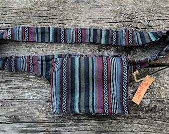 May include: A black and blue striped fanny pack with a brown tag that says "Free Spirit". The fanny pack has a black adjustable strap with a plastic buckle.