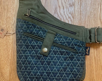 May include: Olive green and navy blue crossbody bag with a geometric pattern. The bag features multiple zippered compartments and an adjustable strap. A small tag is attached to the side.