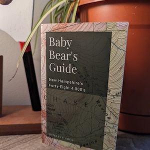May include: A green and brown guide book titled "Baby Bear's Guide" with the text "New Hampshire's Forty-Eight 4,000's" on the cover.