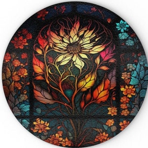 Puede incluir: Un diseño redondo de vitral con una flor estilizada con pétalos amarillos, naranjas, rojos y azules. La flor está rodeada de flores más pequeñas y hojas de varios colores.