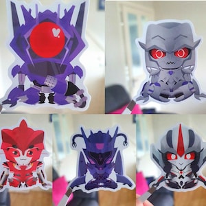 May include: Five colorful robot character stickers. The stickers feature a variety of designs, including robots in purple, gray, red, and blue. Each sticker has a unique robot design with distinct features and colors. The stickers are cut out and ready to be used.