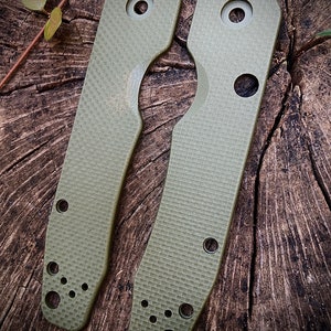 May include: Two green, textured, plastic scales for a pocket knife. The scales have multiple holes for attaching to the knife.