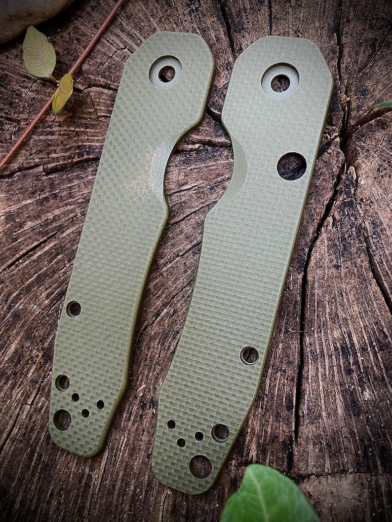 May include: Two green, textured, plastic scales for a pocket knife. The scales have multiple holes for attaching to the knife.