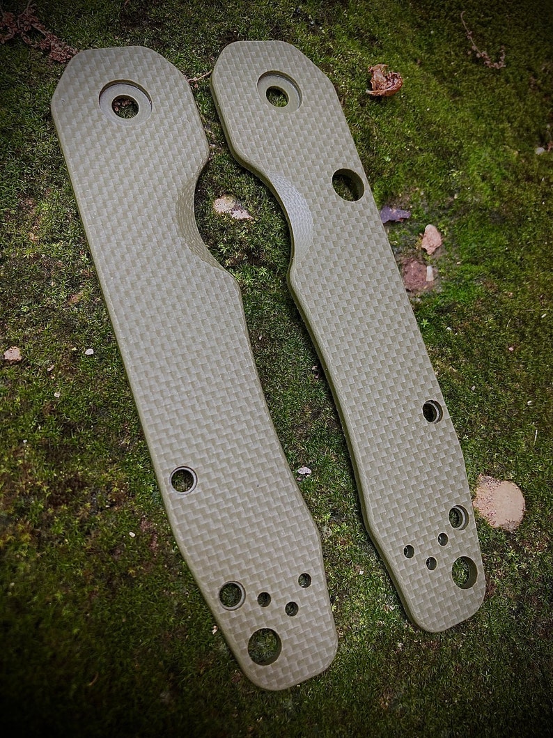 May include: Two green carbon fiber knife scales with rounded edges and multiple holes.