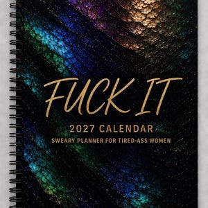 May include: A spiral-bound 2027 calendar with a black cover featuring a textured, iridescent pattern in shades of blue, purple, and gold. The text FUCK IT is printed in large gold letters, followed by 2027 CALENDAR and SWEARY PLANNER FOR TIRED-ASS WOMEN.