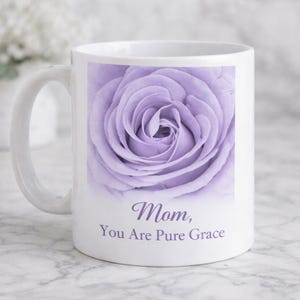 May include: White ceramic mug with a lavender rose image. The mug has a curved handle and the text "Mom, You Are Pure Grace" in a script font.