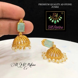 Könnte beinhalten: Ein Paar goldene Ohrringe mit einem hellblauen quadratischen Stein und einem Fransen aus weißen Perlen. Die Ohrringe heißen "Premium Quality AD Stone Jumki".
