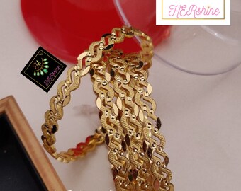 May include: Four gold-coloured bangles with a wavy design. The bangles are stacked on top of each other. The text "4. Pic Golden Bangals Size. 2/4. 2/6. 2/8. 2/10" is visible at the bottom of the image.