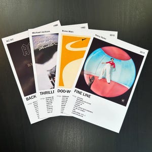 May include: Five album covers with white borders and black text. The album covers are for Back in Black by AC/DC, Thriller by Michael Jackson, Doo-Wops & Hooligans by Bruno Mars, Fine Line by Harry Styles, and Fine Line by Harry Styles.