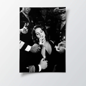 May include: Black and white photograph of a woman in a black dress being lit a cigarette by several people in military uniforms. The image is a portrait, with the woman in the center.