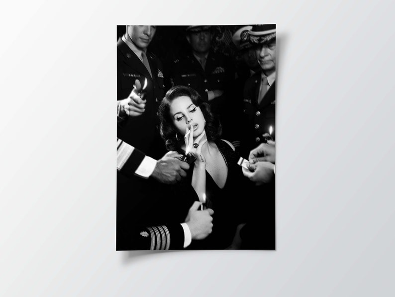 May include: Black and white photograph of a woman in a black dress being lit a cigarette by several people in military uniforms. The image is a portrait, with the woman in the center.