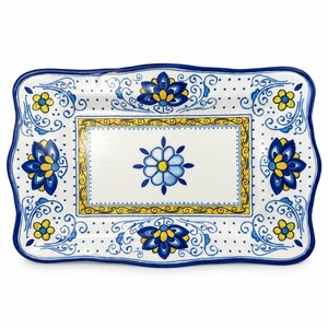 May include: A rectangular ceramic serving tray with a scalloped edge, featuring a white base decorated with hand-painted blue and yellow floral motifs, intricate scrollwork, and a central blue flower surrounded by a yellow rectangular border.