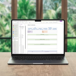 May include: A dark gray laptop displaying a digital project overview document on its screen. The document features a table with headers including Project Overview, Project Timeline, and Project Summary, with a sidebar listing various project files.