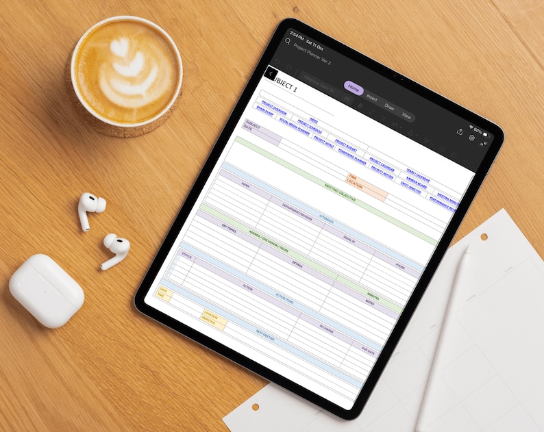 May include: A digital tablet displaying a project planner template with sections for subject, date, meeting objective, attendees, and action items. The screen shows a structured grid layout with purple, green, and yellow headers for organized project management.