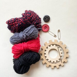 red and black  yarn, wooden flower looms, needle and buttons
