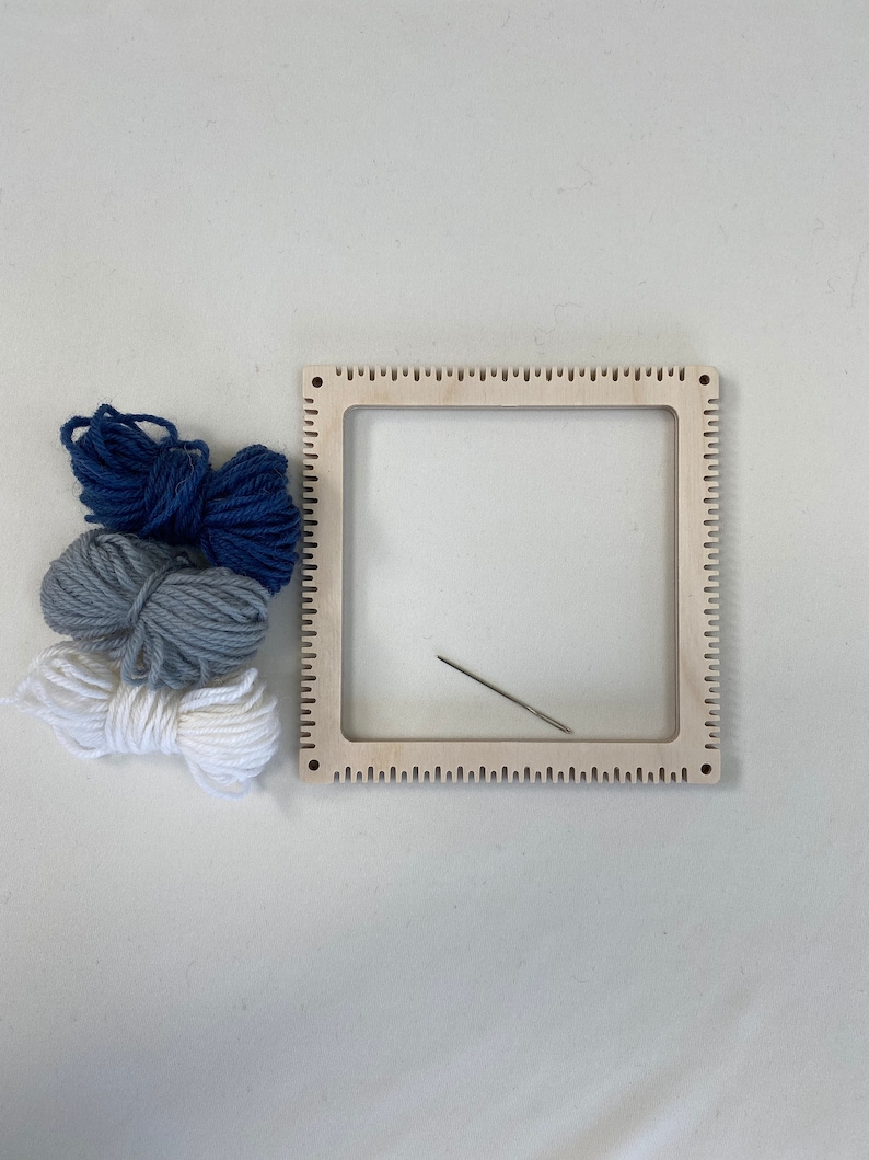 Blue grey and white yarn with a pinless pin loom and needle.