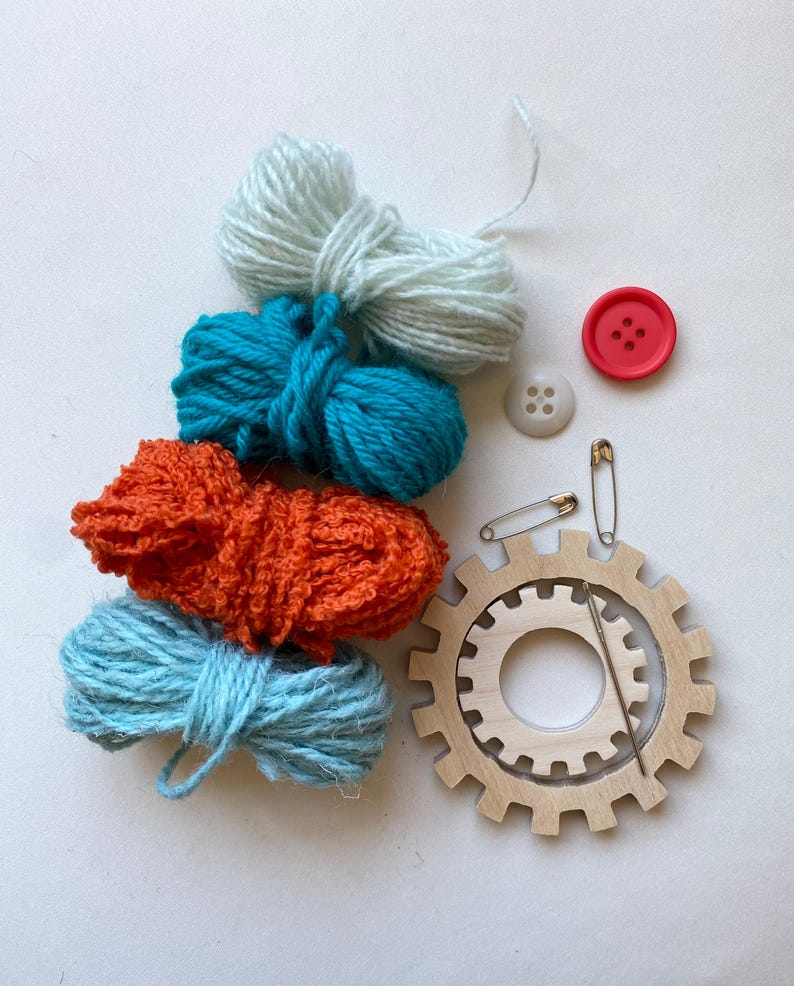 orange and turquoise yarn, wooden flower looms, needle and buttons