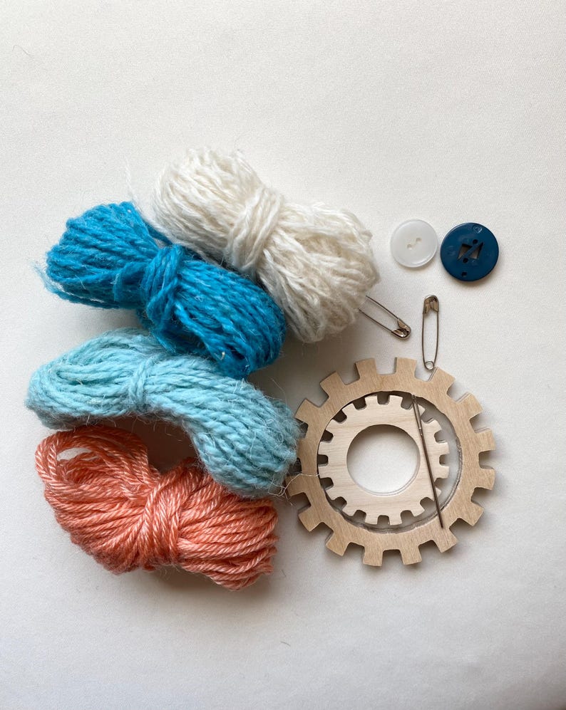 orange and teal yarn, wooden flower looms, needle and buttons