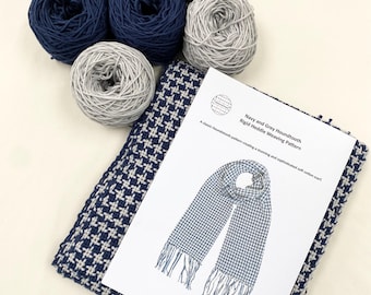 Op de afbeelding: Een weefset voor een navyblauwe en grijze ruitjes sjaal. De set bevat garen in beide kleuren en een patroon voor een starre kamweefgetouw.
