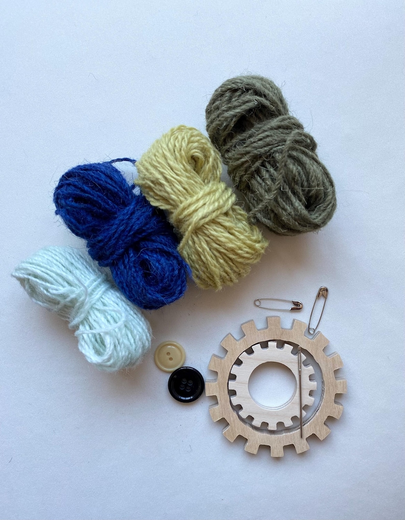 green and blue yarn, wooden flower looms, needle and buttons