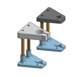 Può includere: Due dispositivi meccanici con piani triangolari grigi, supportati da molle arancioni e basi azzurro chiaro. Un piano è grigio. Ogni base ha un foro circolare e due fessure. I dispositivi sono progettati per uso industriale.