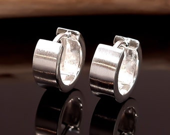 May include: A pair of silver hoop earrings with a smooth, brushed finish. The earrings are simple and elegant, and would make a great gift.