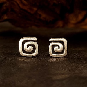 May include: A pair of silver earrings with a square shape and a spiral design.