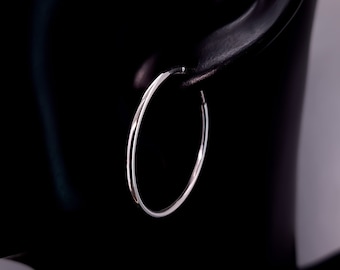 May include: A pair of silver hoop earrings. The earrings are simple and elegant, and they would be a great addition to any jewelry collection.