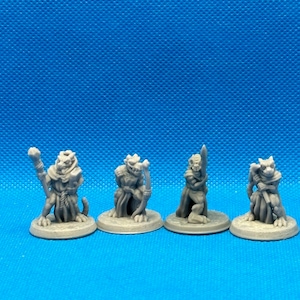 May include: Four miniature figurines of lizard-like creatures, each with a different pose and holding a weapon or staff. The figurines are painted in a gray color and are standing on round bases.
