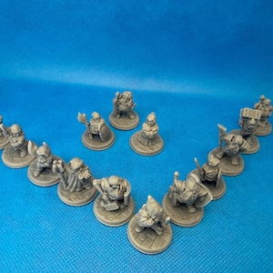May include: A collection of miniature gray dwarf figurines, each on a circular base. The dwarves are in various poses, some holding weapons like axes and hammers. The figurines are arranged in a V-shape against a blue background.