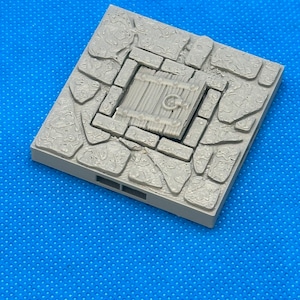 May include: A gray, square, stone-textured tile with a small wooden door with a metal ring handle. The tile is designed for use in tabletop games.