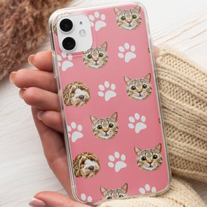 May include: A pink phone case with a repeating pattern of white paw prints and images of cats and dogs.