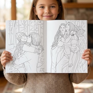 May include: A coloring book with two illustrations of people hugging. One shows two people embracing in a forest setting, and the other shows two people hugging near a tree. The book is held open by a person.