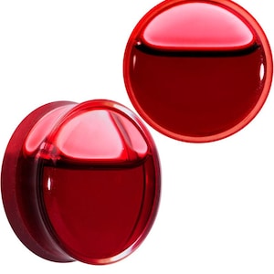 May include: Pair of red glass ear gauges. The gauges are round and have a smooth, polished finish.